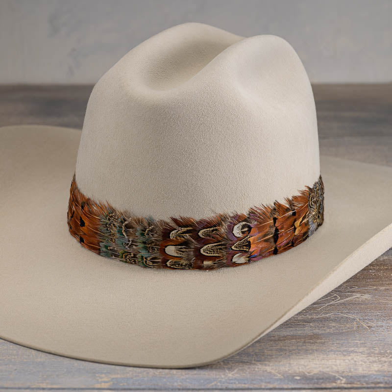 Western feather hat band on cream cowboy hat, multicolor feather trim along brim