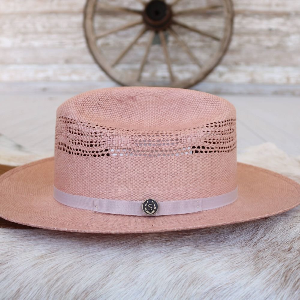 Apricot straw fedora hat with vented band across the crown and round metal emblem