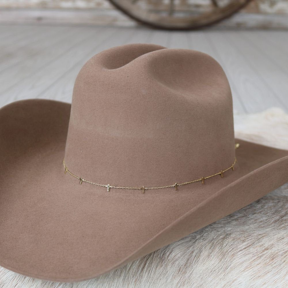 Gold-plated cross hat band chain on a brown cowboy hat