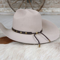 Goat leather hat band with gold studs plus braided cord tie on a light cowboy hat