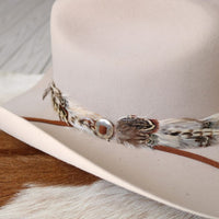 Silver slotted concho on brown leather band with feather detailing