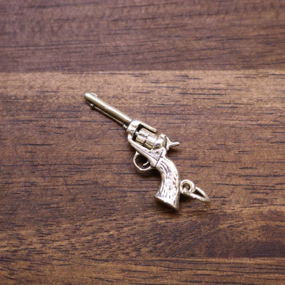 Sterling silver revolver charm with small loop bail and cylinder details