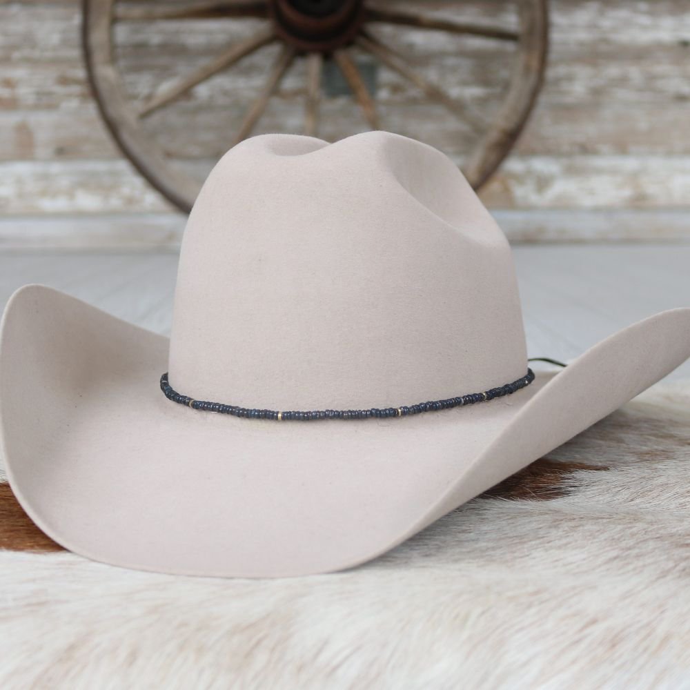 Cleo beaded hat band on white felt cowboy hat, black band with small blue accents