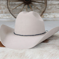 Cleo beaded hat band on white felt cowboy hat, black band with small blue accents