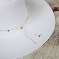 Close-up of gold-plated cross hat band chain with dangling cross charms
