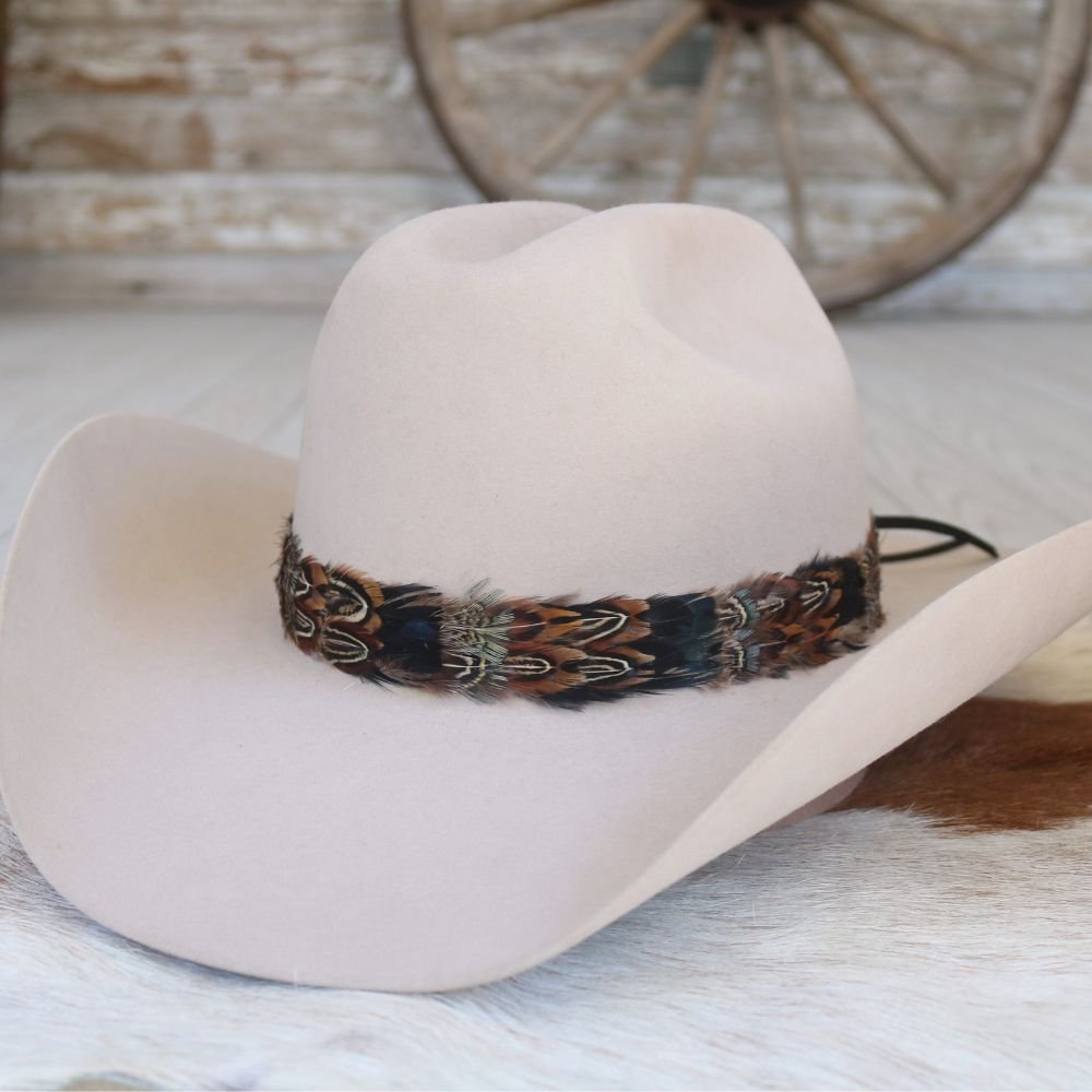 Cream western cowboy hat with a colorful feather-print band around the crown