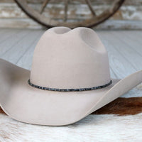 Light gray felt hat with dark beaded stone hat band around brim