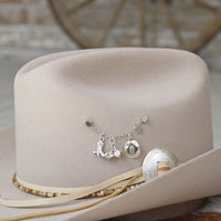 Sterling silver boot charm on charm necklace with metal charms, displayed on hat