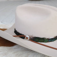 Sterling silver slotted concho on brown leather strap with green feather accents