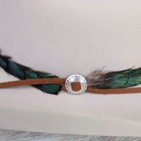 Close-up sterling silver slotted concho with round center detail on feather trim