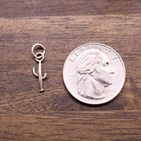 Sterling silver saguaro cactus charm next to US quarter coin for scale