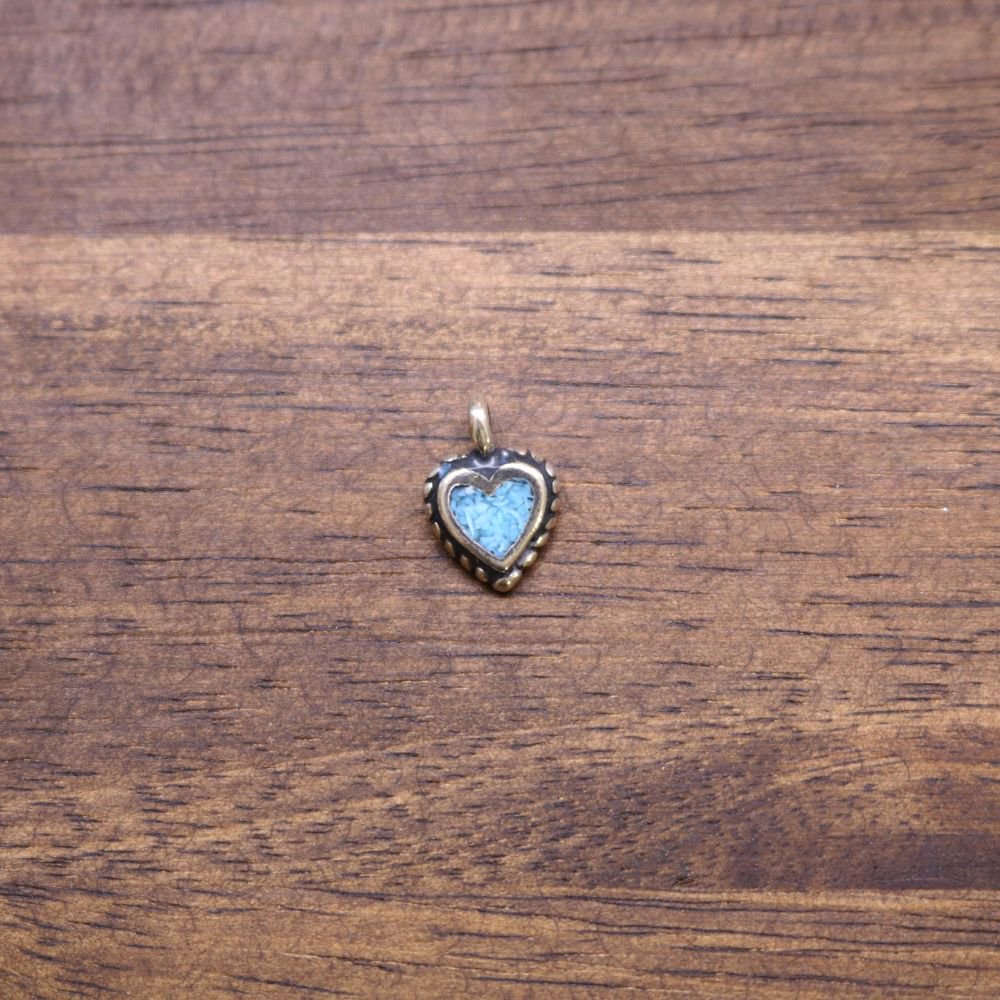Heart-shaped charm with light blue inlay and loop bail at top