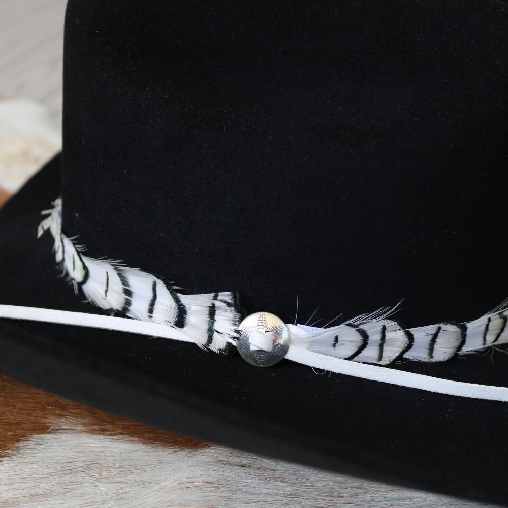 Silver slotted concho set on feather-trimmed band