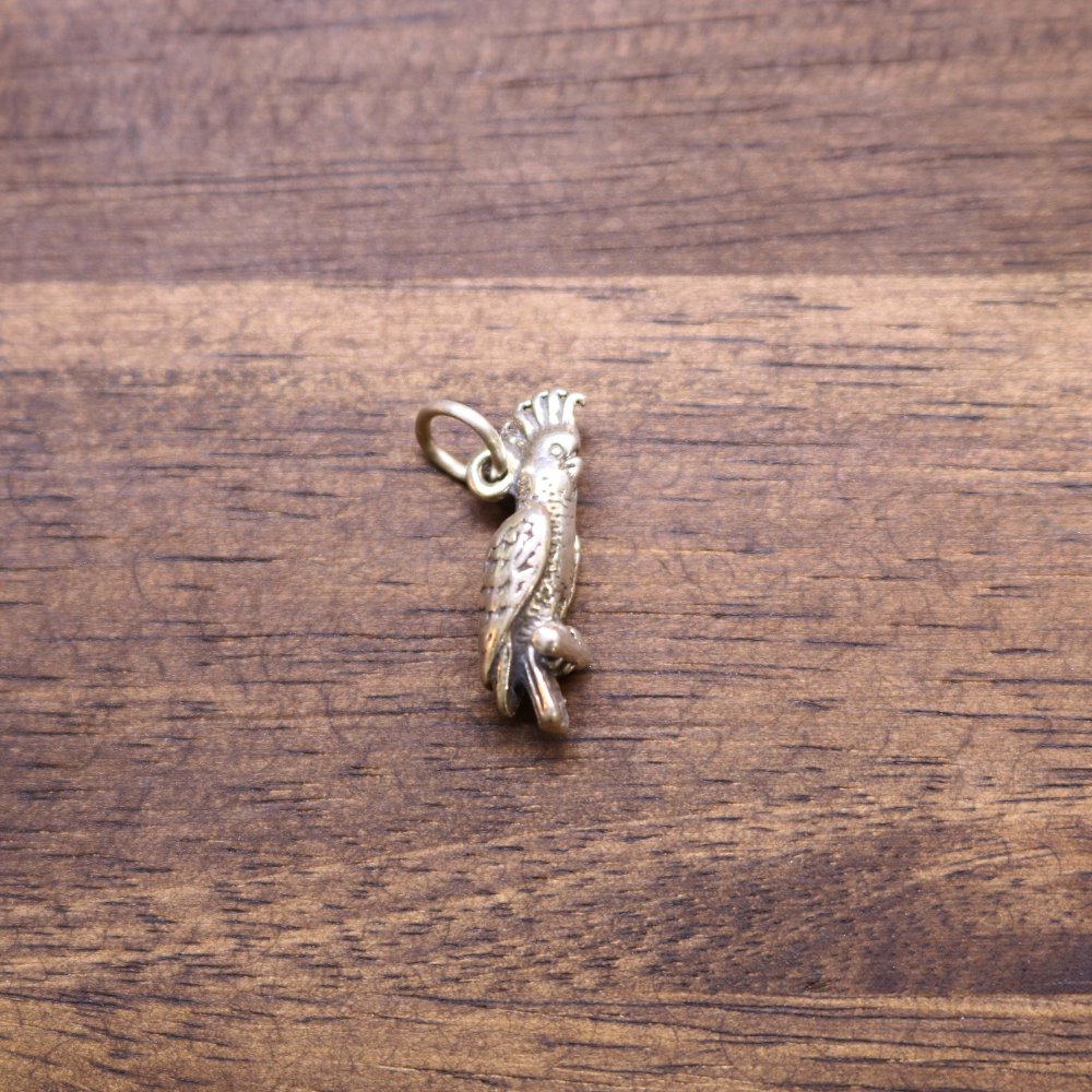 Sterling silver cockatoo charm with detailed bird figure and loop bail at top
