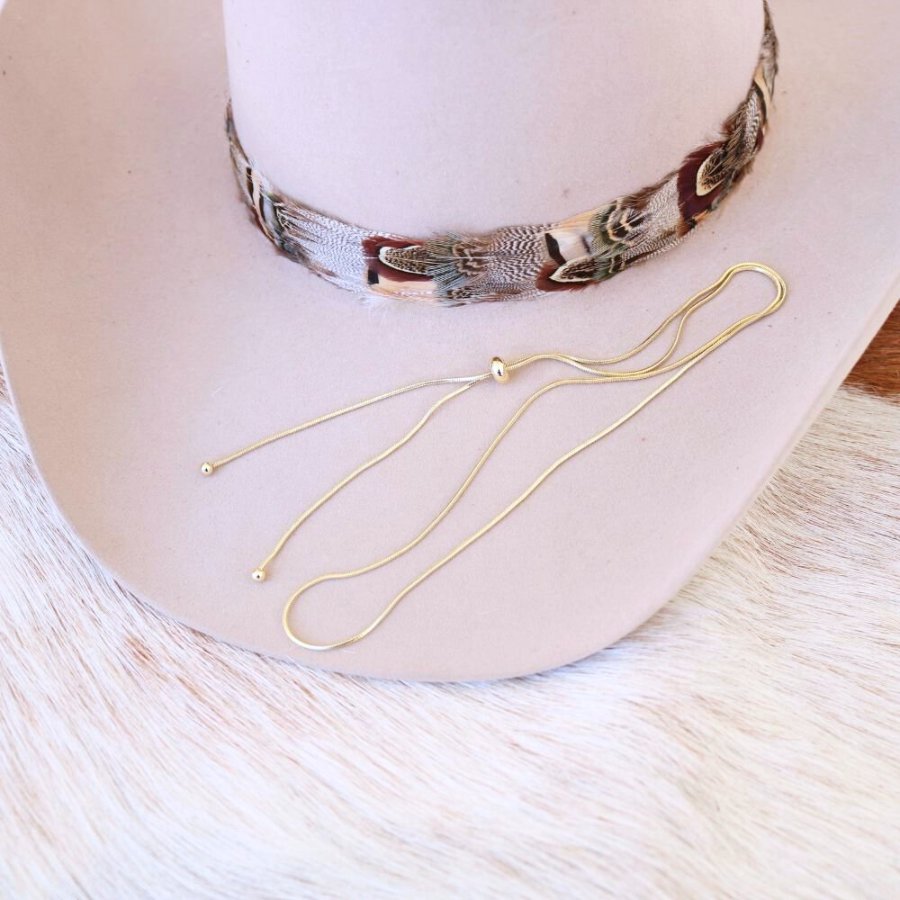 White hat mannequin with gold-tone snake chain hat band and long chain strands