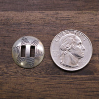 Sterling silver slotted concho beside a quarter coin for size