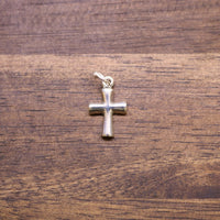Sterling silver cross charm with small loop bail, polished finish.