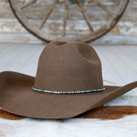 Brown felt cowboy hat with turquoise beaded hat band on brim